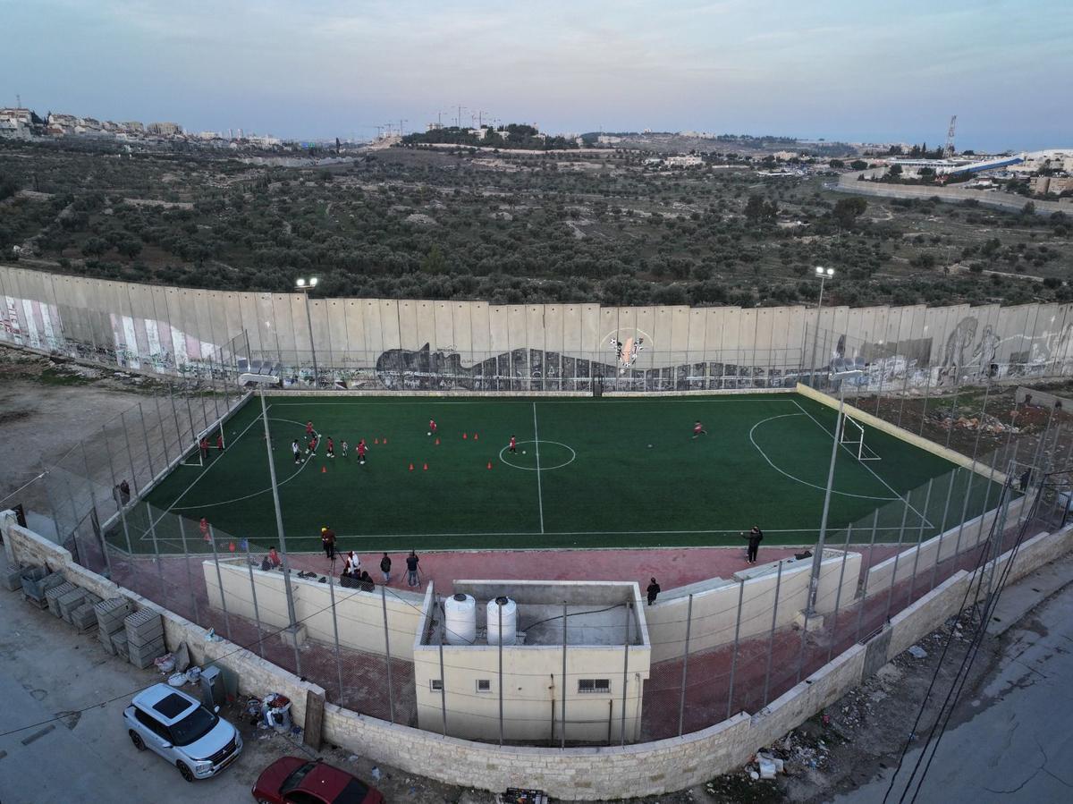 Un grupo de niños refugiados jugando fútbol en el estadio del campamento de refugiados Aida en Belén. (Fuente: El Periódico)