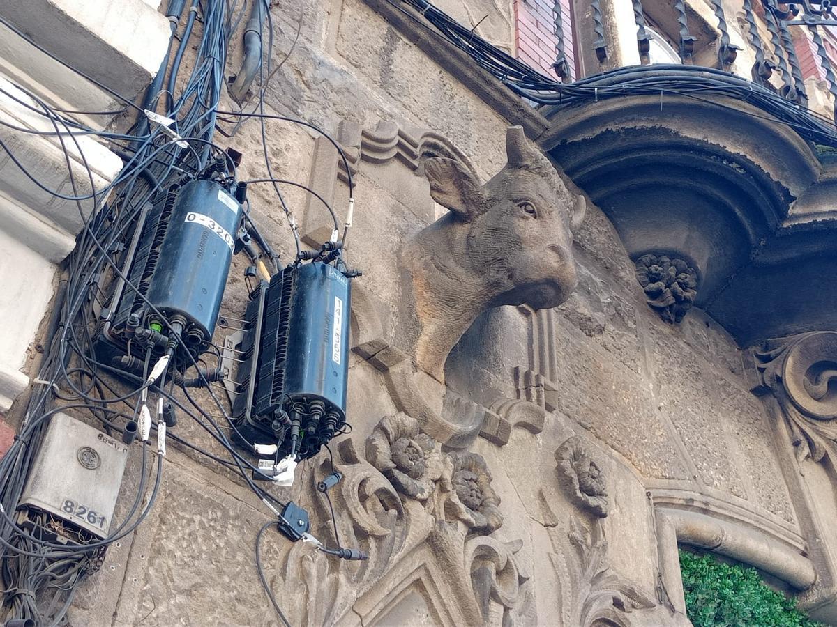 Cajas y cables de fibra óptica en la fachada de un edificio en Barcelona. (Fuente: El Periódico)