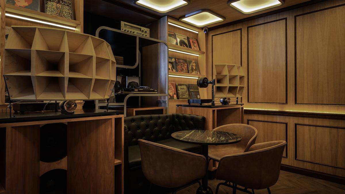El interior de un 'listening bar' con una decoración en madera y un equipo de sonido en el centro. (Fuente: El Periódico)
