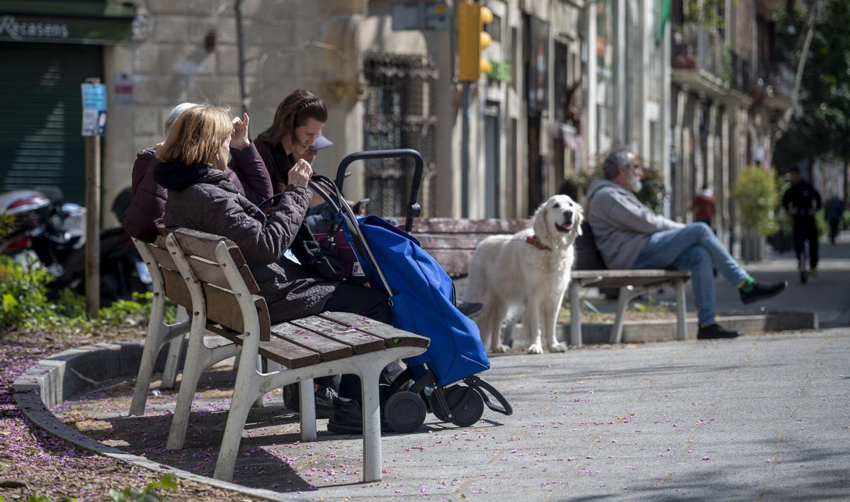 Una familia sentada en un banco en la Gran Via de les Corts Catalanes de Barcelona (Fuente: El Periódico)