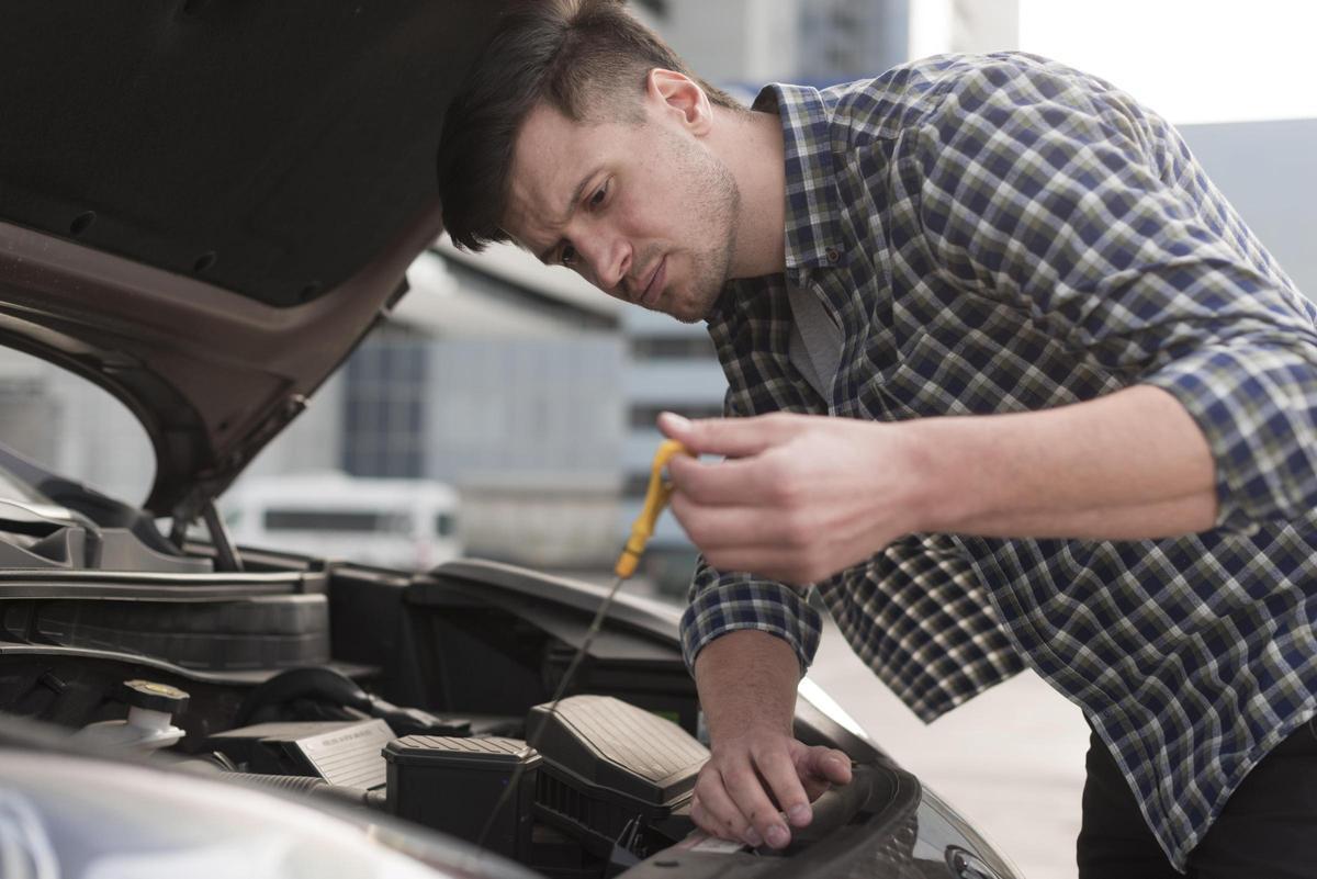 Persona revisando el aceite del motor de su coche para mantenerlo en buen estado (Fuente: El Periódico)