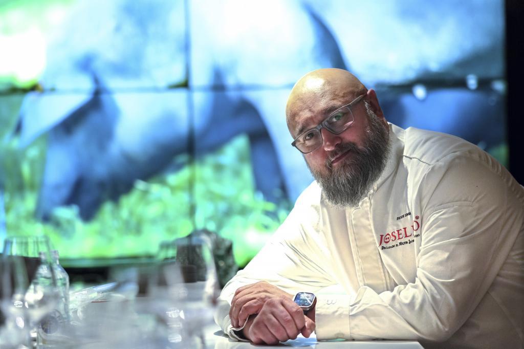 Ernesto Soriano, cortador de jamones de Joselito, sonriendo mientras trabaja con un jamón de alta calidad. (Fuente: El Mundo)
