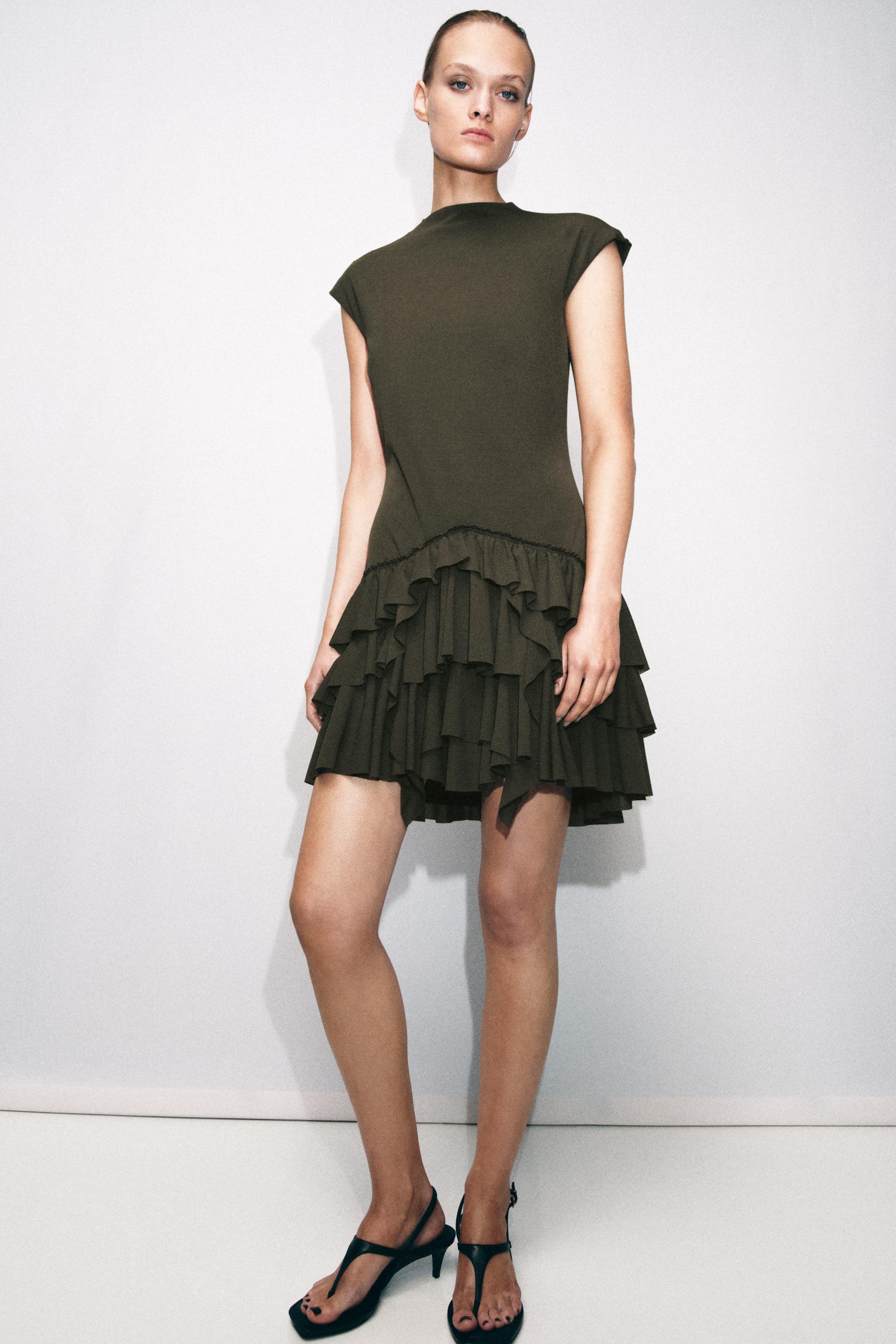 Vestido corto de Zara en color verde caqui con volantes en el bajo, perfecto para un look atrevido. (Fuente: El Mundo)