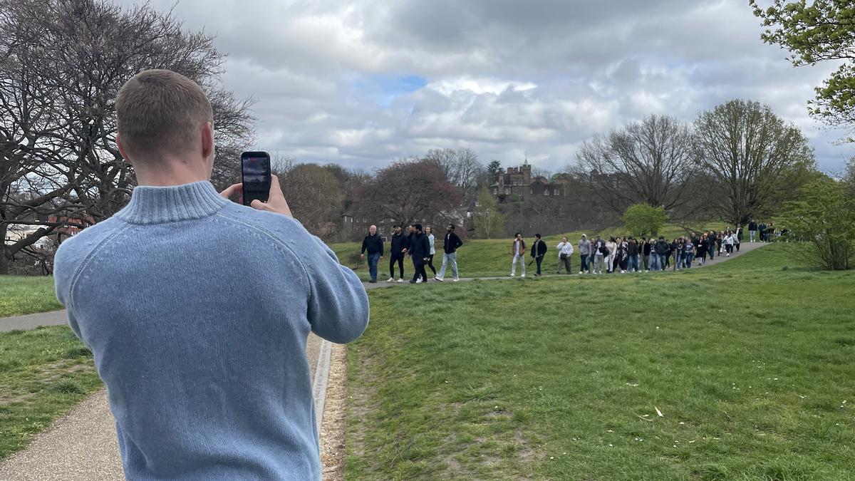 Participantes del paseo grupal intercambiando conversaciones mientras recorren los senderos del parque