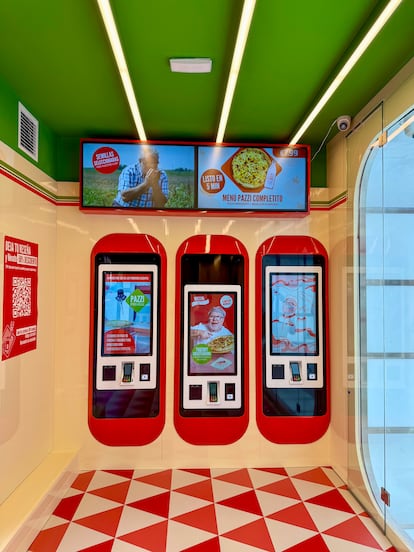 Interior de la pizzería Pazzi con brazos robóticos preparando pizza