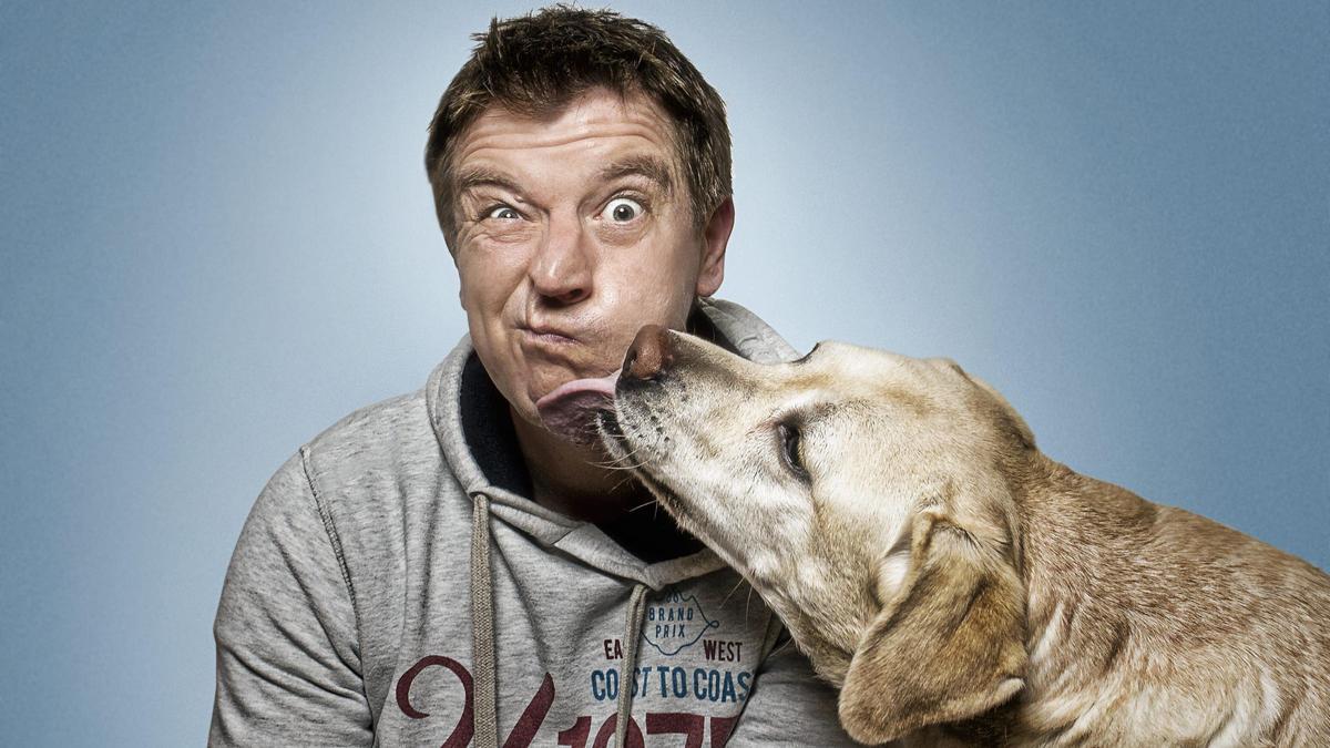 Christian Vieler ajustando su cámara mientras un perro atrapa un premio en el estudio