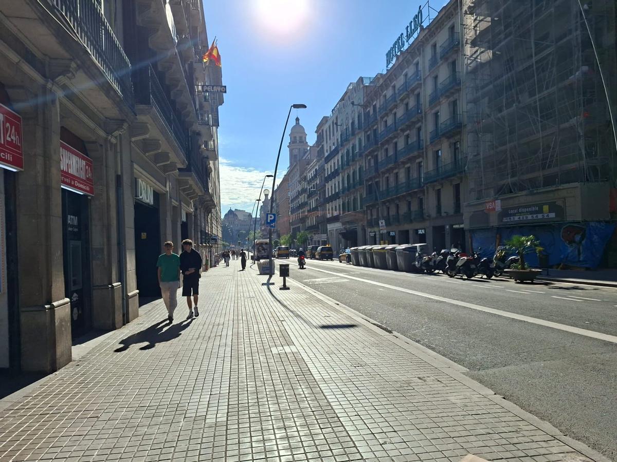 Vista panorámica de la calle Pelai con contenedores y motos en la acera