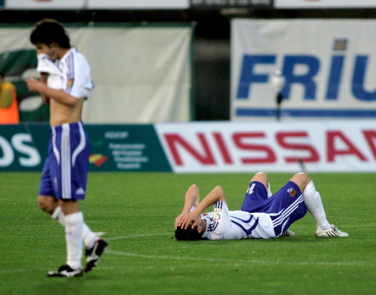 Kike García del Espanyol cabecea un balón junto a Javi López del Oviedo