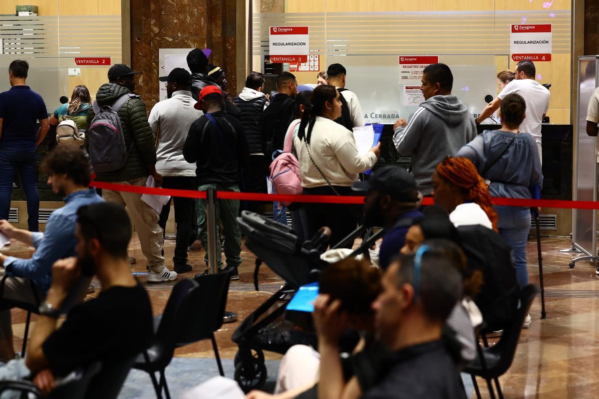 Mujer rellenando formulario de solicitud de regularización en el registro municipal de Zaragoza