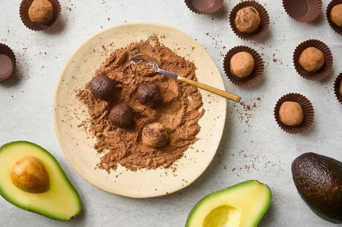 Aguacates cortados sobre una tabla, con fondo de pista de running