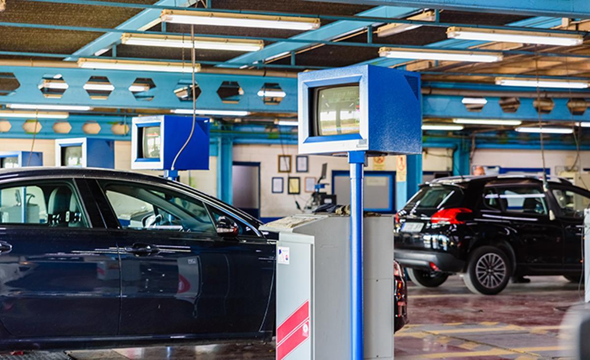 Coche en la fila de una estación de ITV, mostrando la señalización y la pegatina de inspección