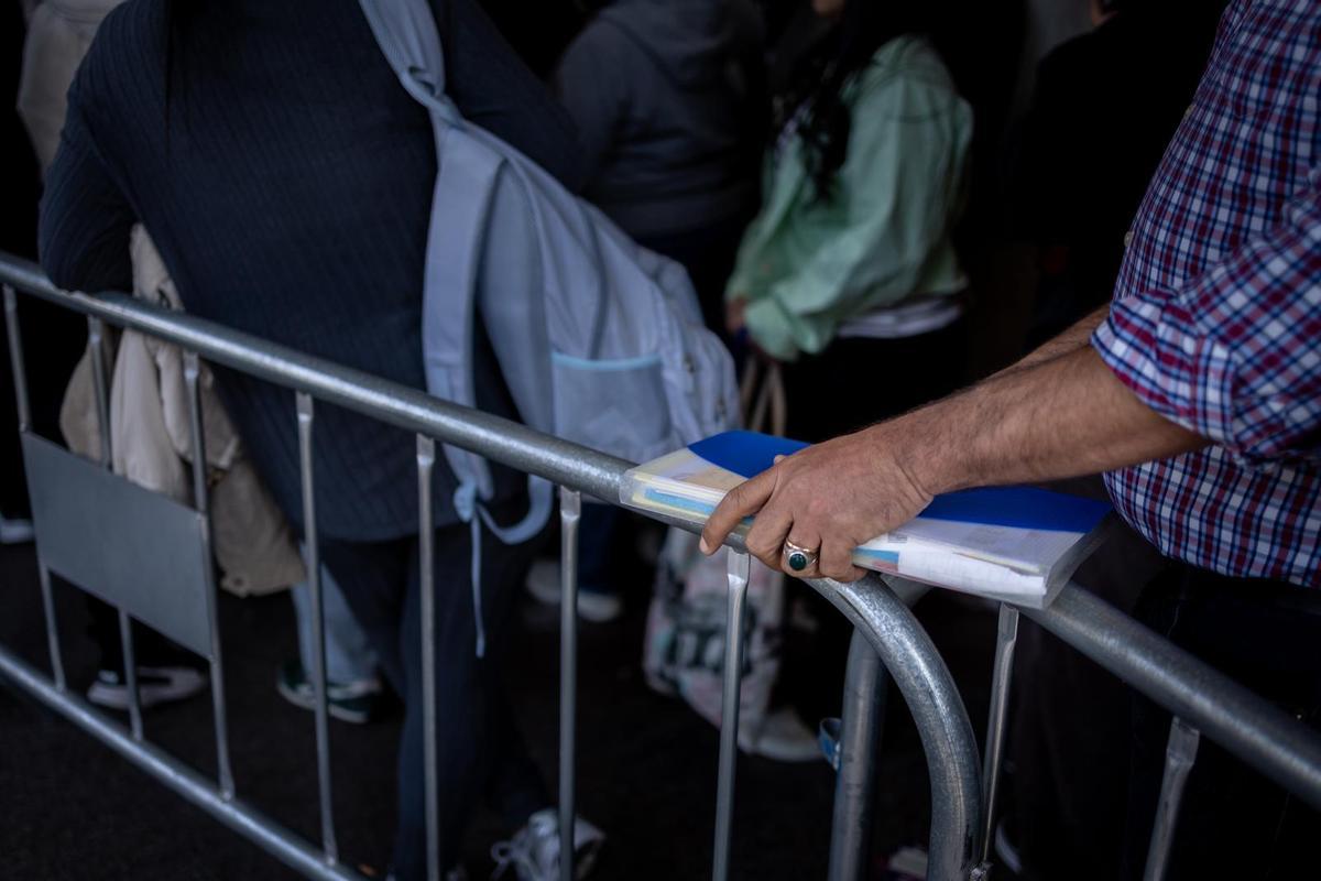 Fila de inmigrantes frente al Ayuntamiento de Zaragoza esperando la cita de regularización