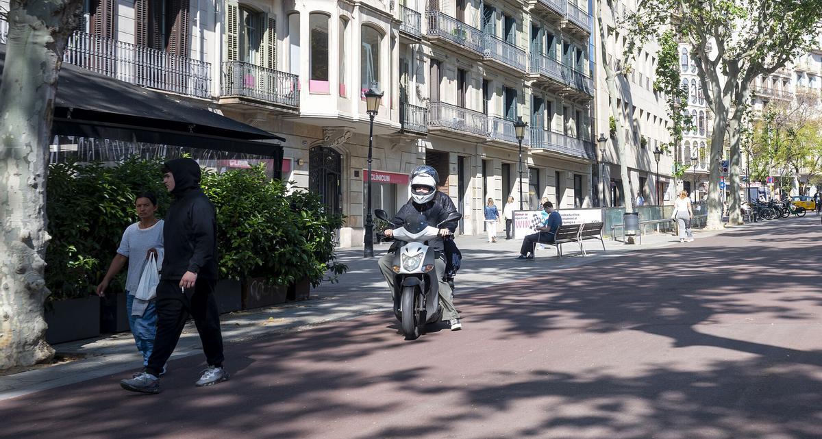 Motorista circulando a alta velocidad por la zona peatonal de los Jardinets del Passeig de Gràcia