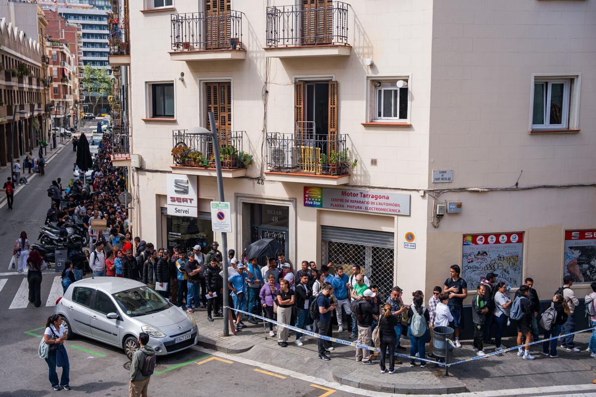 Fila de personas esperando en la Oficina de Benestar Social i Família de Barcelona‑Sants/Eixample
