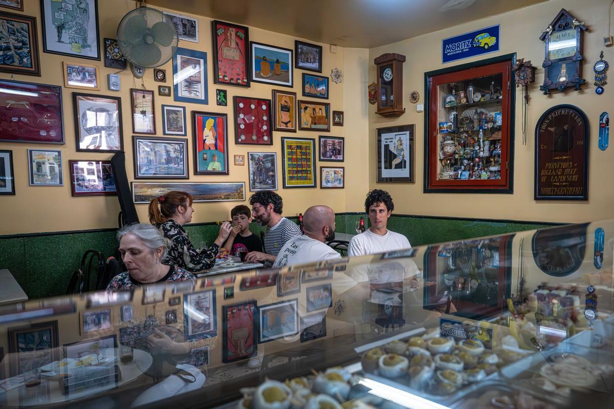Interior de la Vermutería del Tano con mesas de mármol y barra de madera