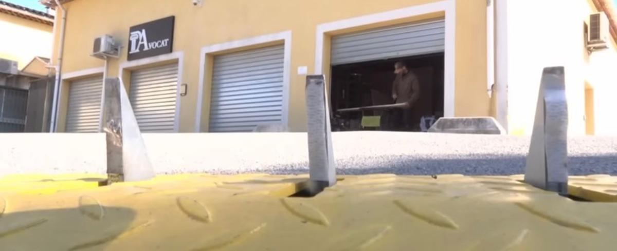 Pinchos instalados en la entrada del parking, visibles bajo la señal de sentido único