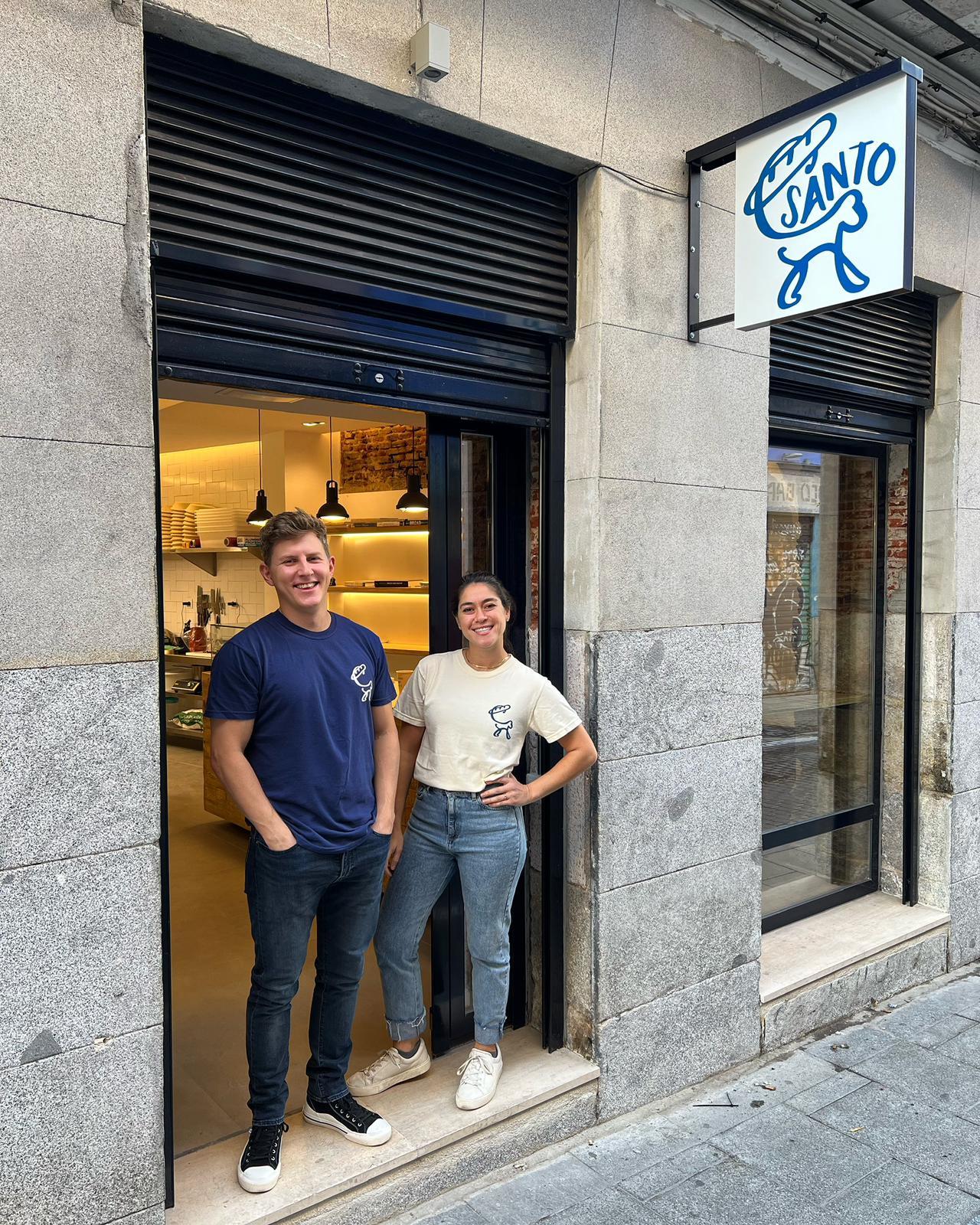 Fila de clientes frente a la fachada azul de Santo Bakehouse en la calle Espíritu Santo, Malasaña
