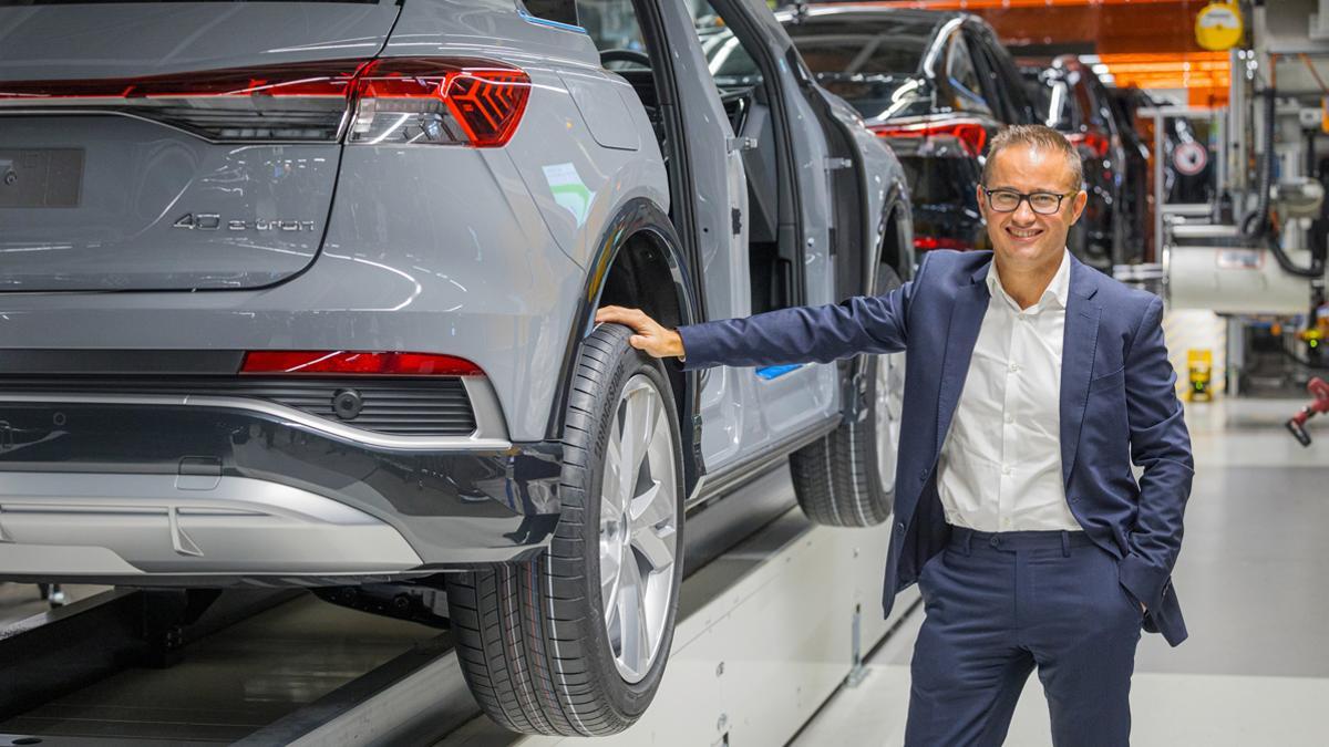 Fermín Soneira hablando en el Beijing Auto Show, con fondo del stand de Audi China