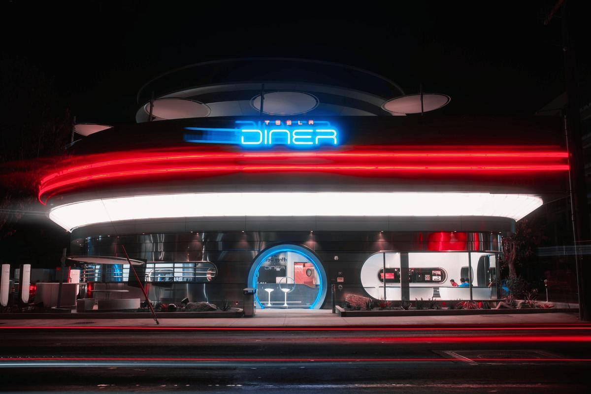 Mesas de madera donde los conductores disfrutan la pizza mientras recargan