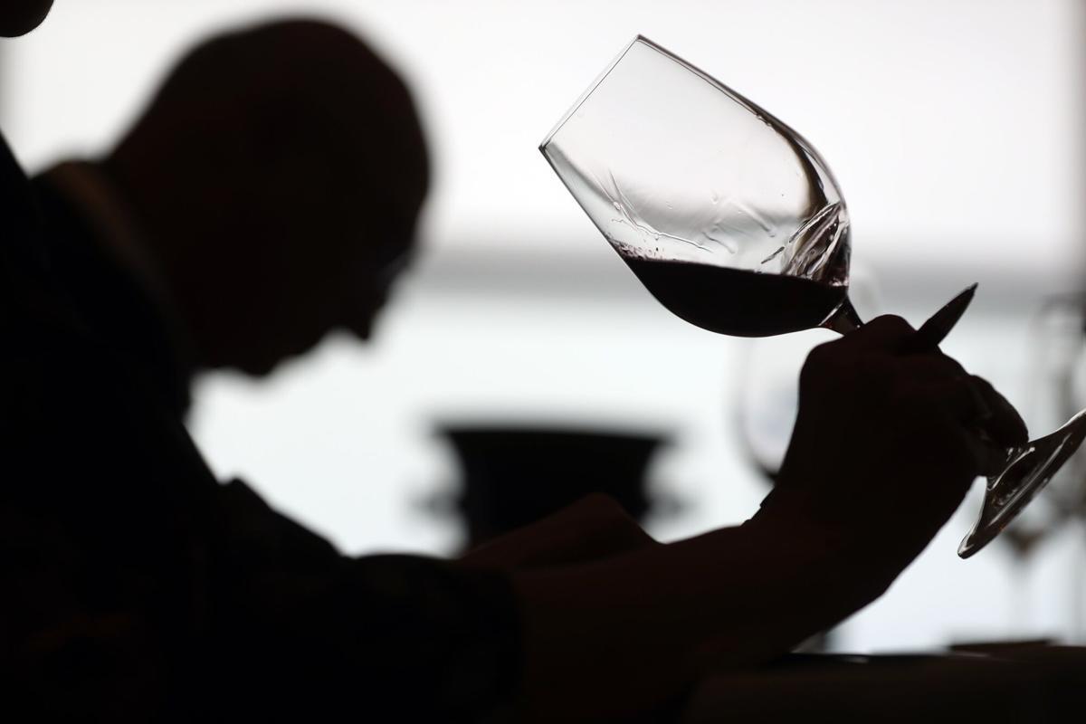 Persona sirviendo vino blanco en una copa