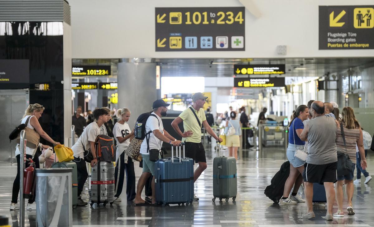 Pasajeros en aeropuerto canario esperando facturar