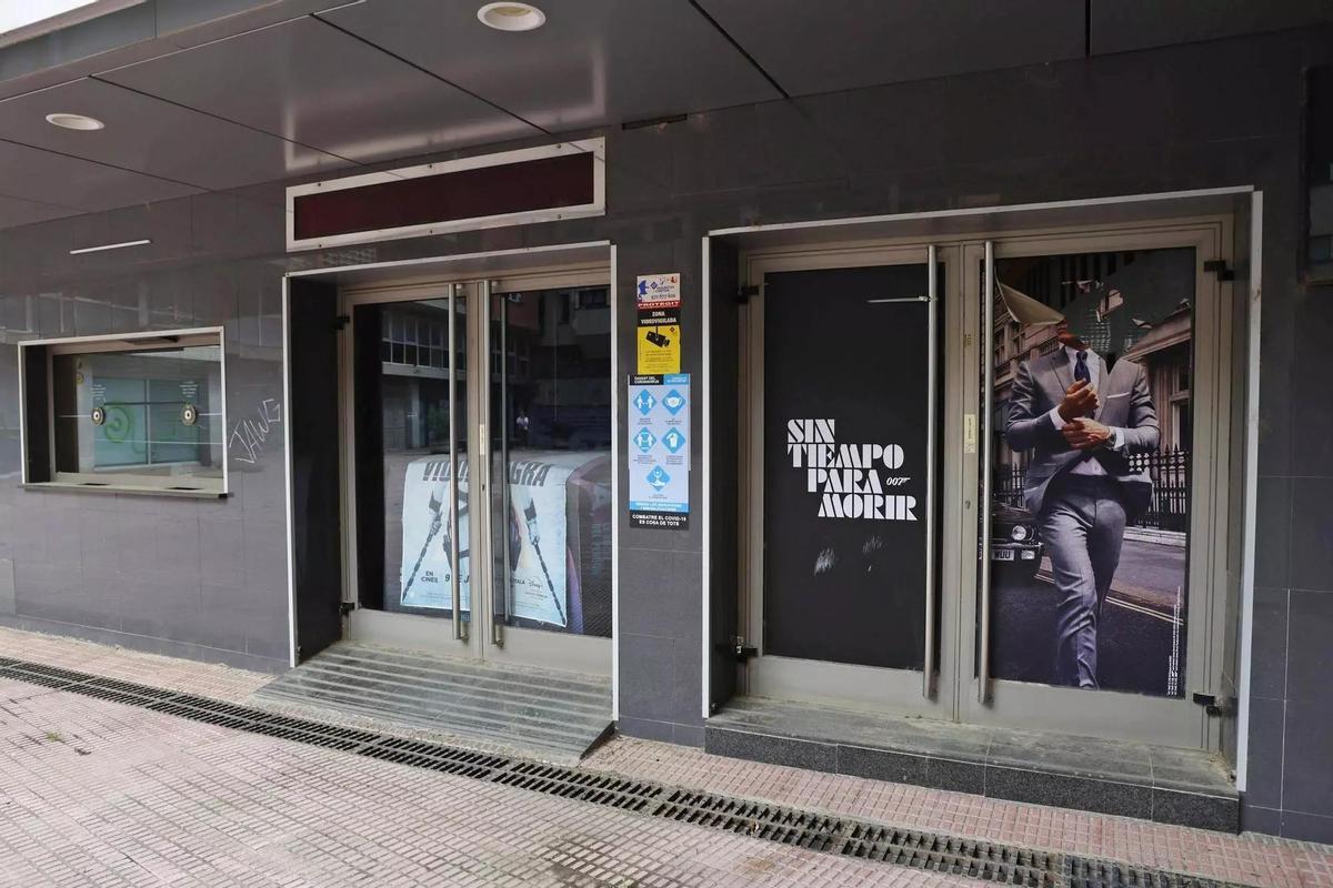 Fachada deteriorada de los cines Albèniz Plaça, cubierta de polvo y grafitis