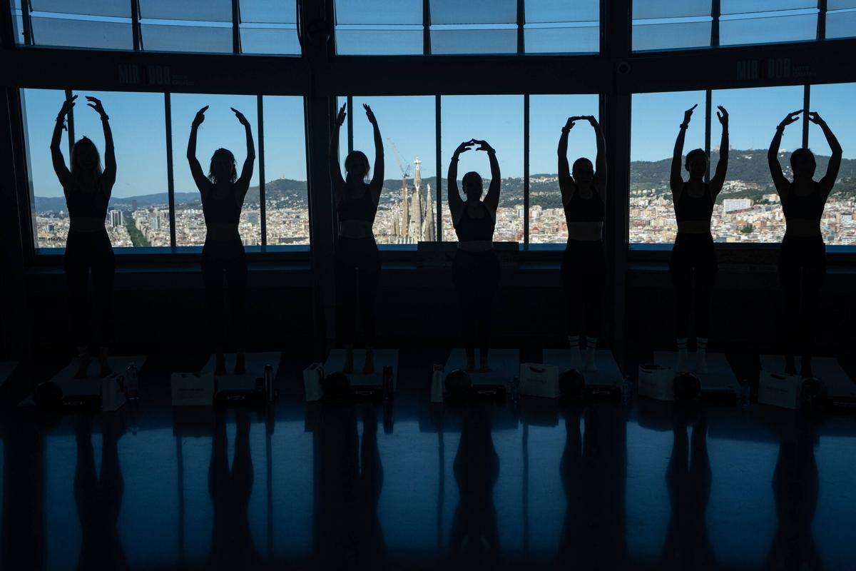 Vista panorámica de la Torre Glòries con participantes de la clase de Kick The Barre al fondo.