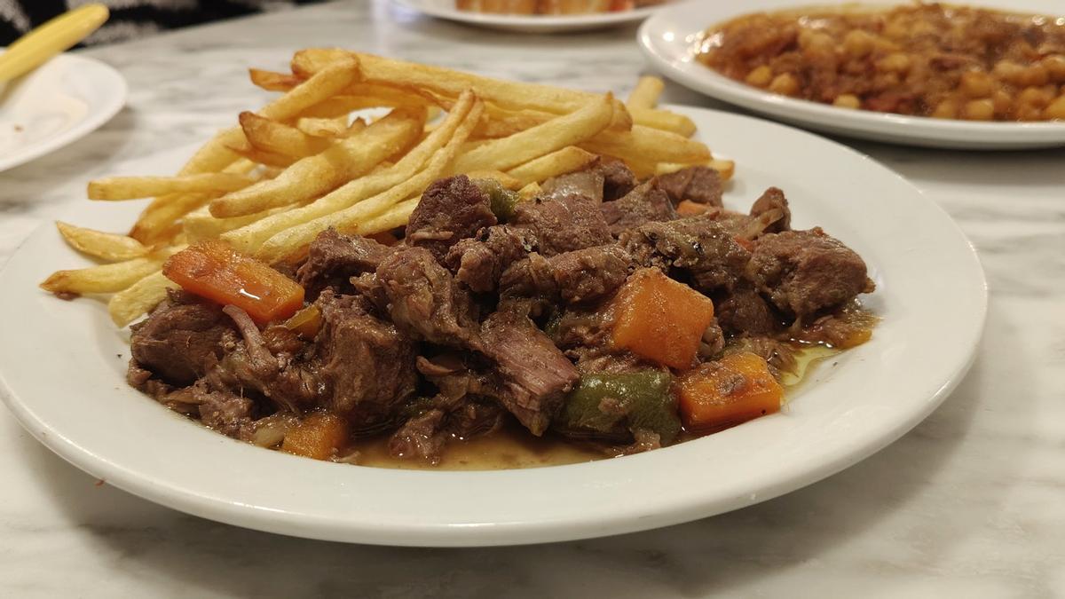 Interior del Bar Casi cerca del Park Güell, con mesas de madera y platos tradicionales