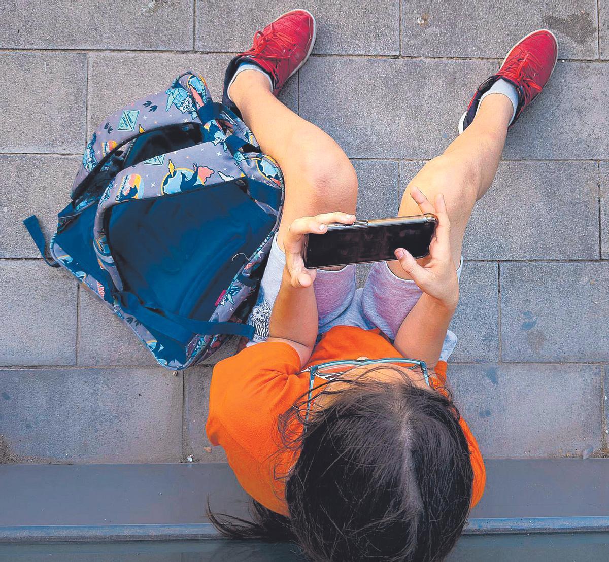 Niño mirando el móvil antes de dormir, ilustrando el uso nocturno del smartphone