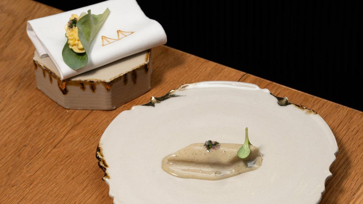 Interior del comedor de Mont Bar, con mesas compactas y una barra minimalista