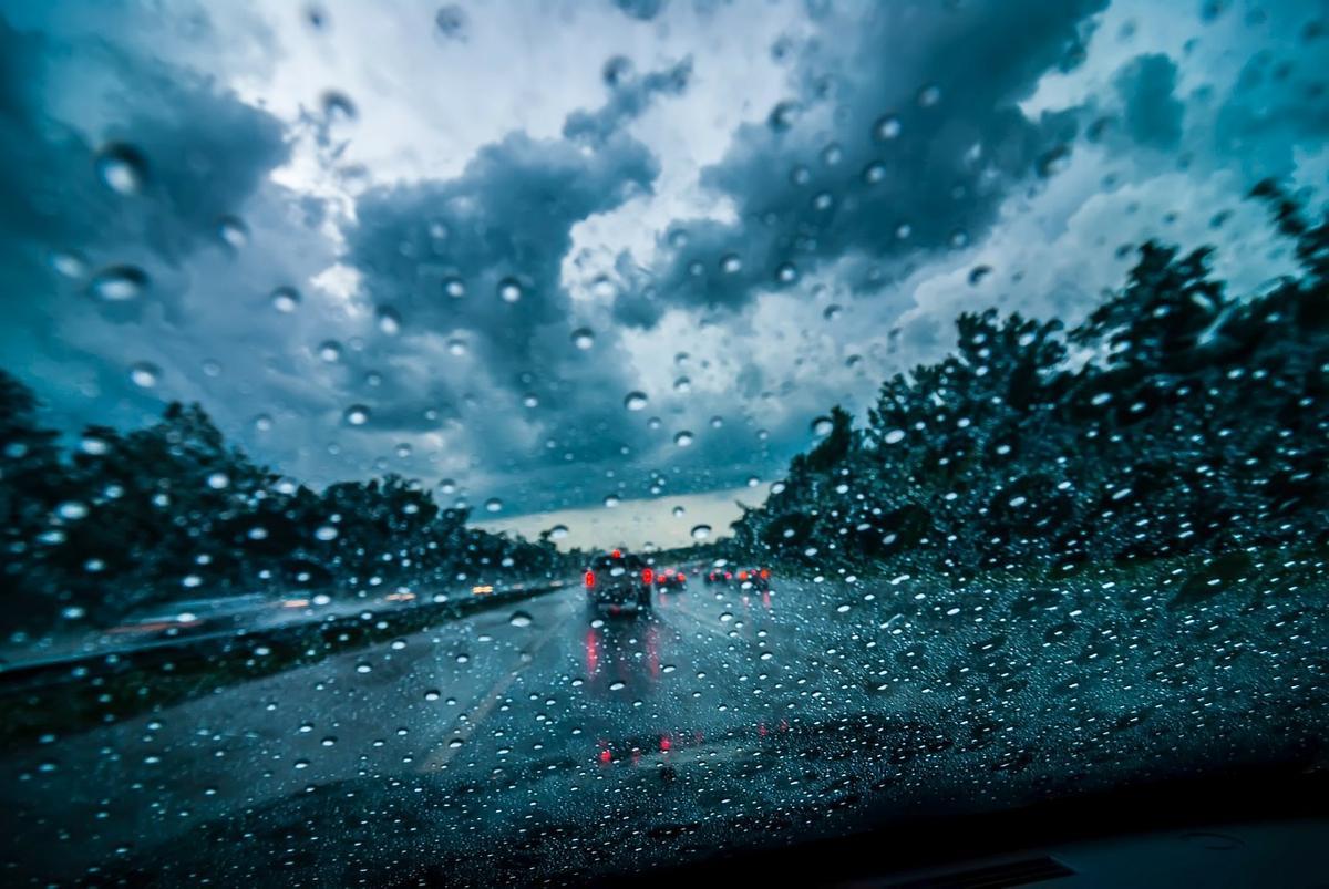 Coche circulando bajo una intensa lluvia con el parabrisas cubierto de gotas