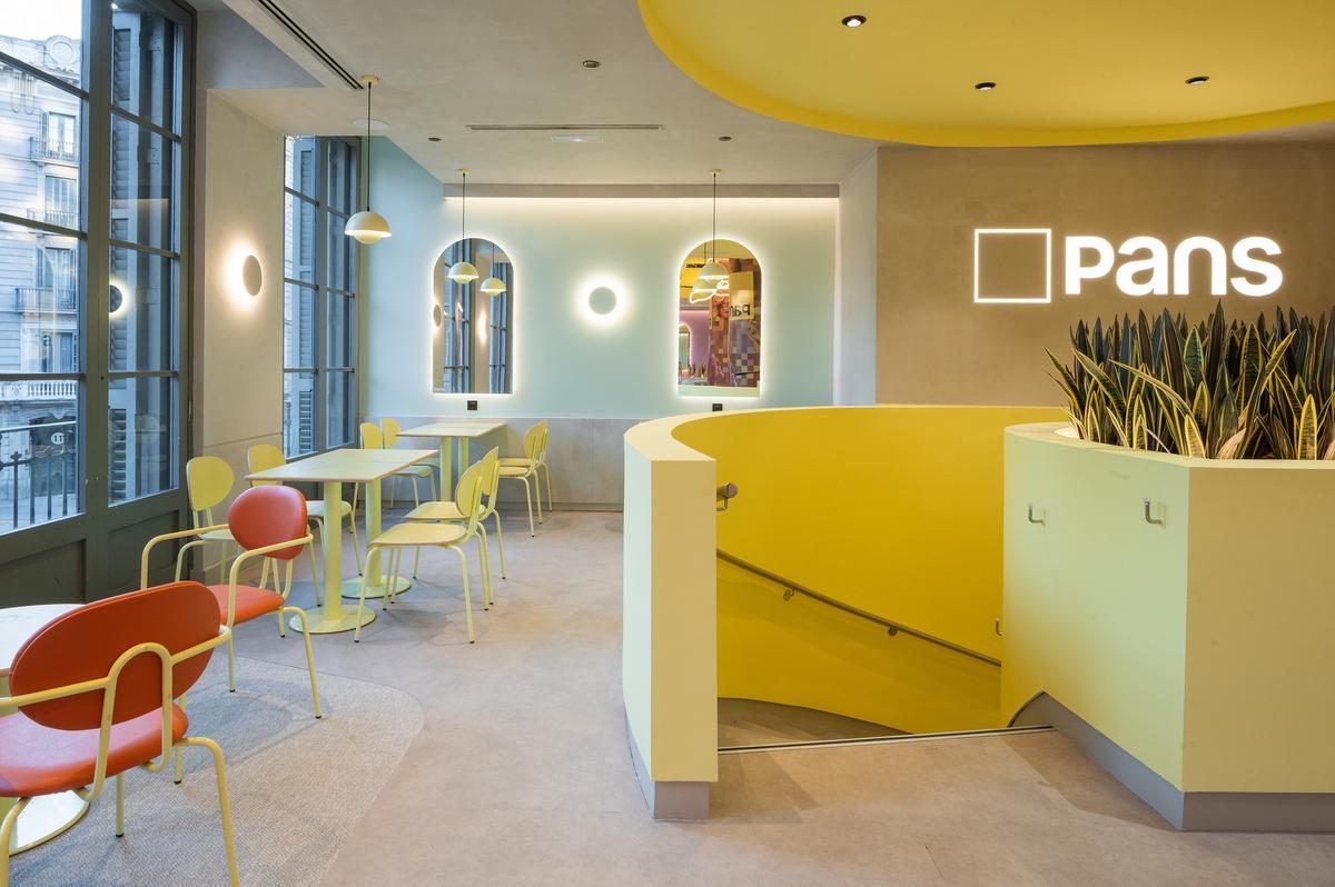 Interior renovado de PANS en la plaza de Urquinaona, Barcelona, con diseño minimalista y materiales naturales