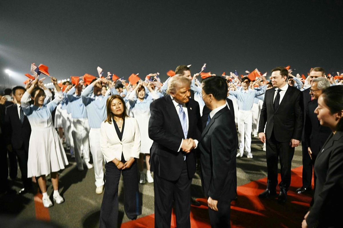 Donald Trump desembarca del Air Force One en el Aeropuerto Internacional de Pekín, rodeado de autoridades chinas y banderas.