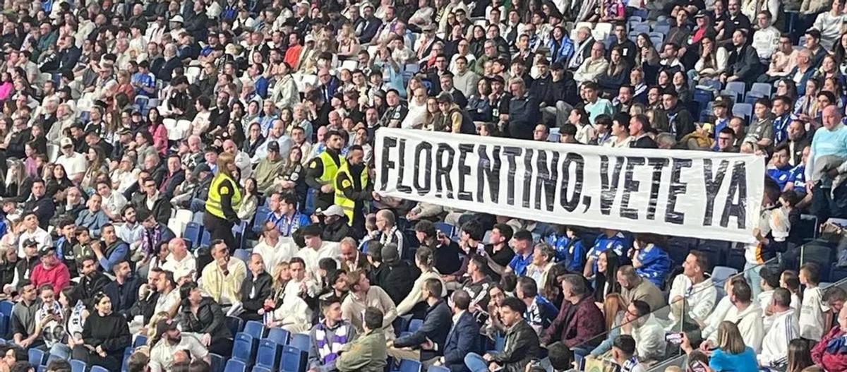 Aficionados retirando una pancarta anti‑Florentino en el estadio Santiago Bernabéu