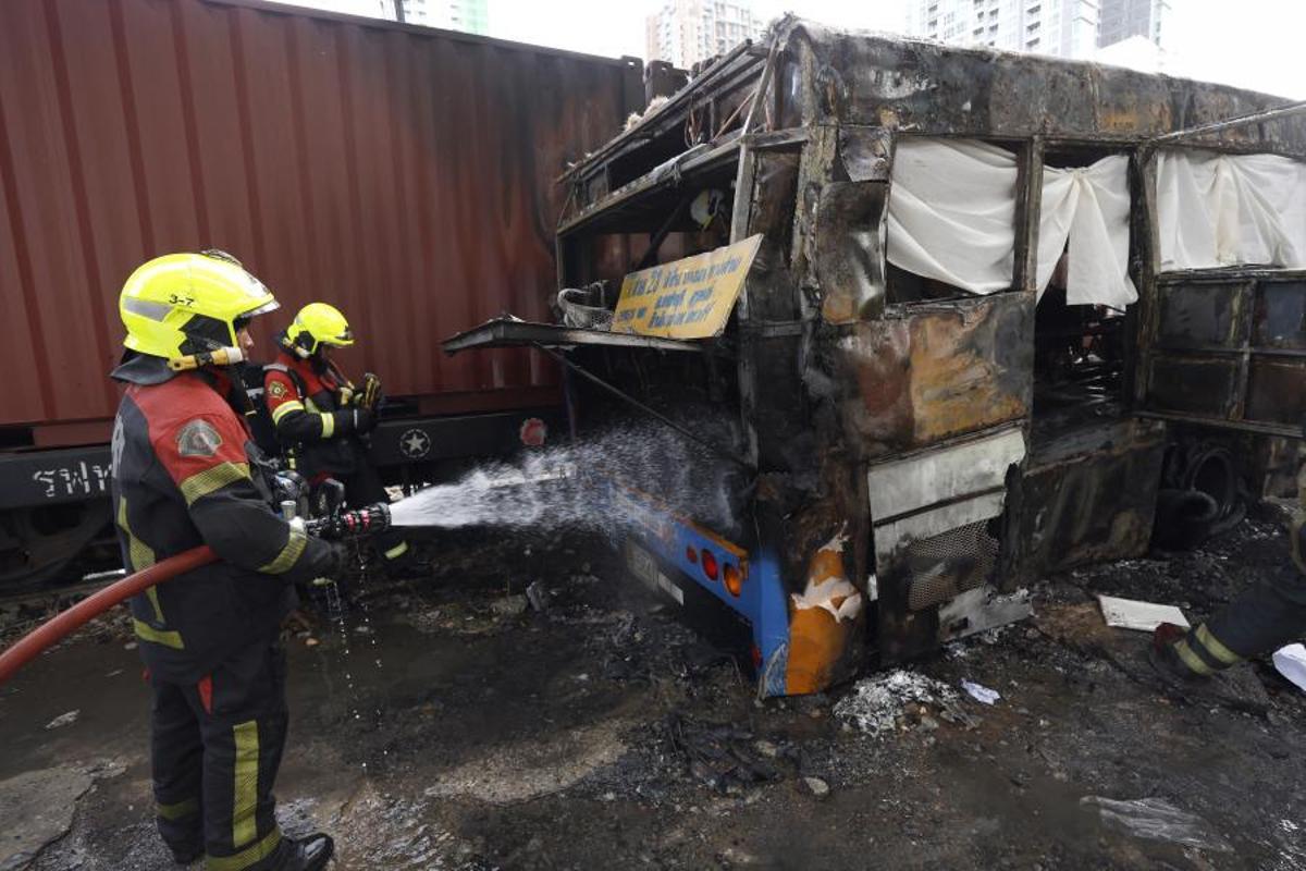 Bomberos apagando el incendio del autobús tras el choque