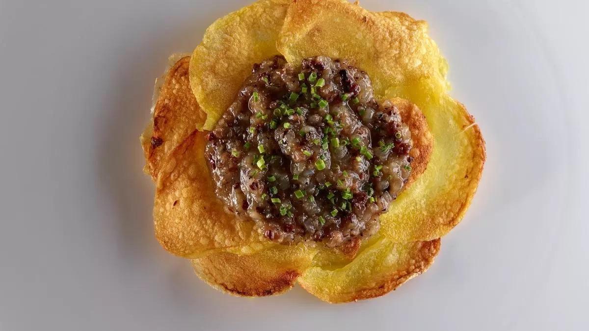 Detalle de un plato típico catalán servido en uno de los locales de la lista, como peus de porc o arroz de espardenyes