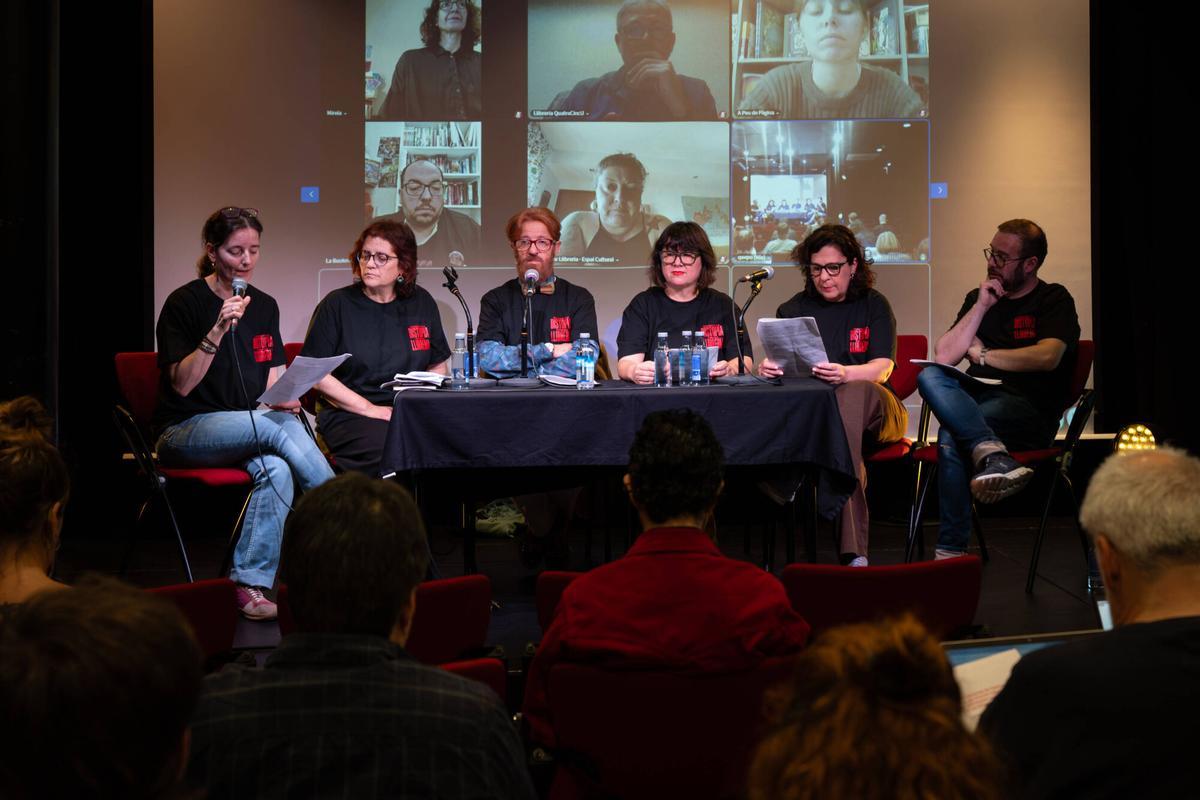 Libreros catalanes presentando la campaña 'Combat la distopia. Tria la llibreria' en una sala de actos.