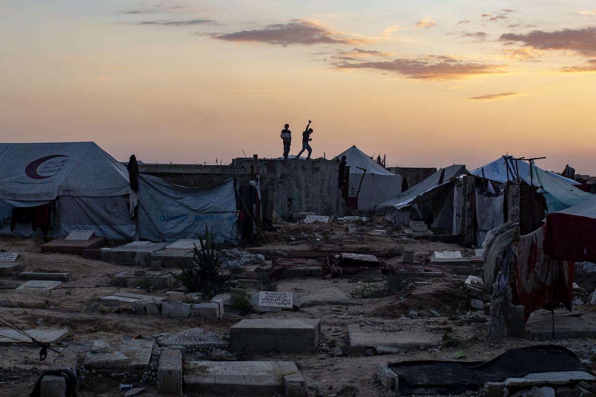 Jóvenes palestinos jugando al fútbol entre tiendas de campaña en el campo de refugiados de Khan Yunis, Gaza