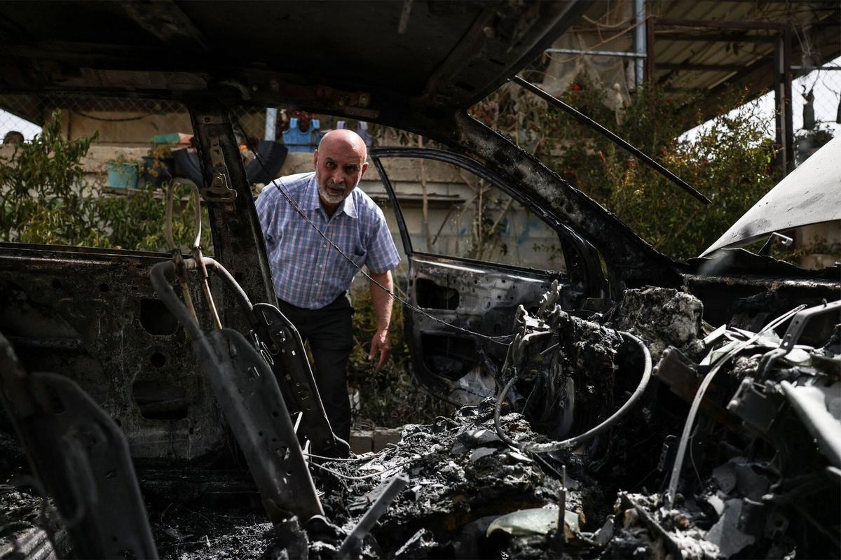 Colonos israelíes incendiando una mezquita en Jibiya, mientras soldados observan