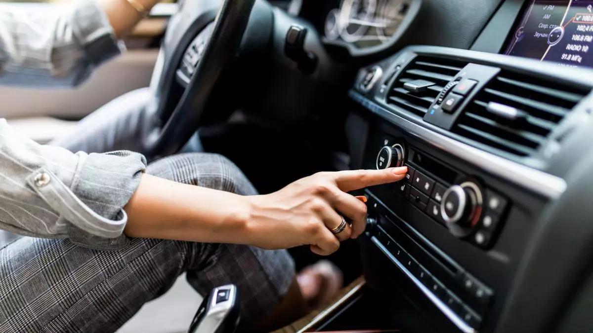 Botón de recirculación en el salpicadero de un coche, con flecha circular