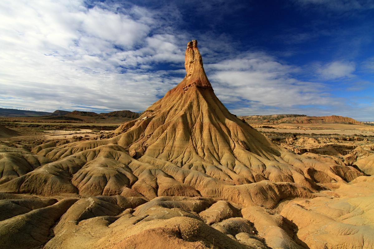 Vista panorámica del paisaje erosionado de las Bardenas Reales, con sus formaciones rocosas y tonalidades desérticas al atardecer