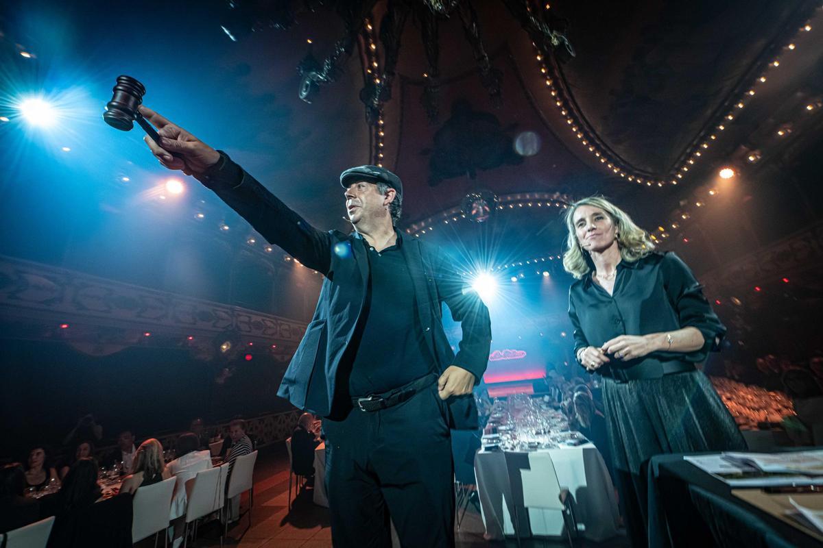 Pilarín Bayés en el escenario de la cena solidaria en La Paloma, rodeada de comensales y luces elegantes