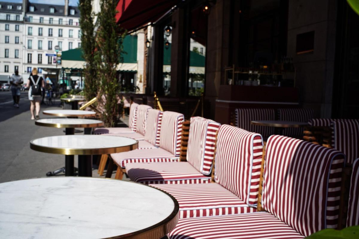 Terraza del Café de l'Olympia en París con sillas trenzadas alineadas a la calle