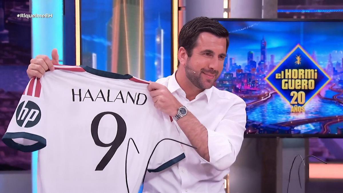 Enrique Riquelme mostrando una camiseta del Real Madrid con el nombre y dorsal 9 de Erling Haaland en El Hormiguero
