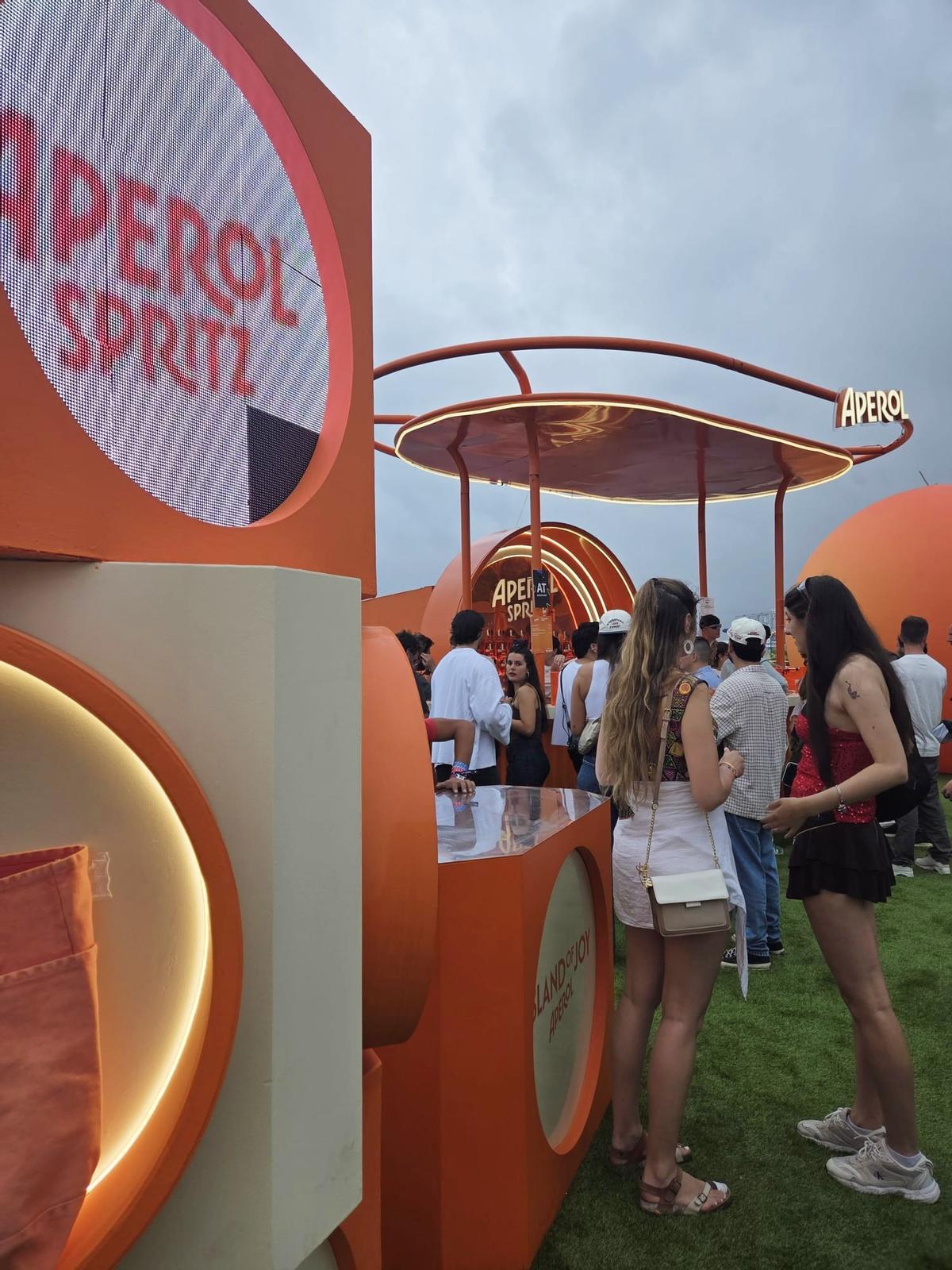 Escena del podcast BOMBIFICADAS en vivo con Samantha Hudson y María Barrier, rodeados de luces cálidas y espectadores