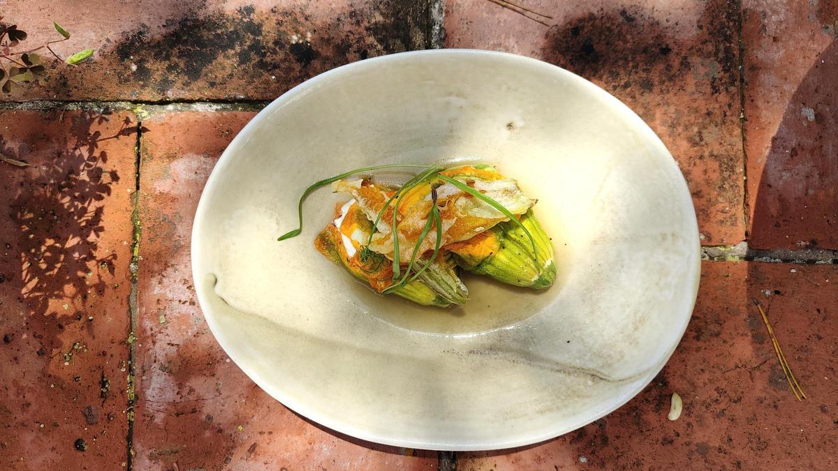 Flores de calabacín rellenas de recuit y buñuelos de chocolate blanco con hierbaluisa, platos emblemáticos de la residencia
