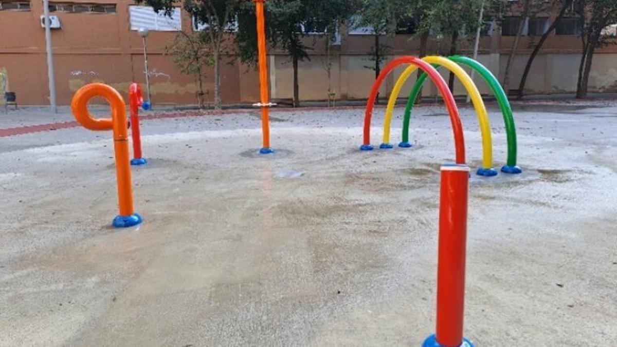Niños jugando en la nueva área de juego de agua de la plaza de Carme Simó, Barcelona