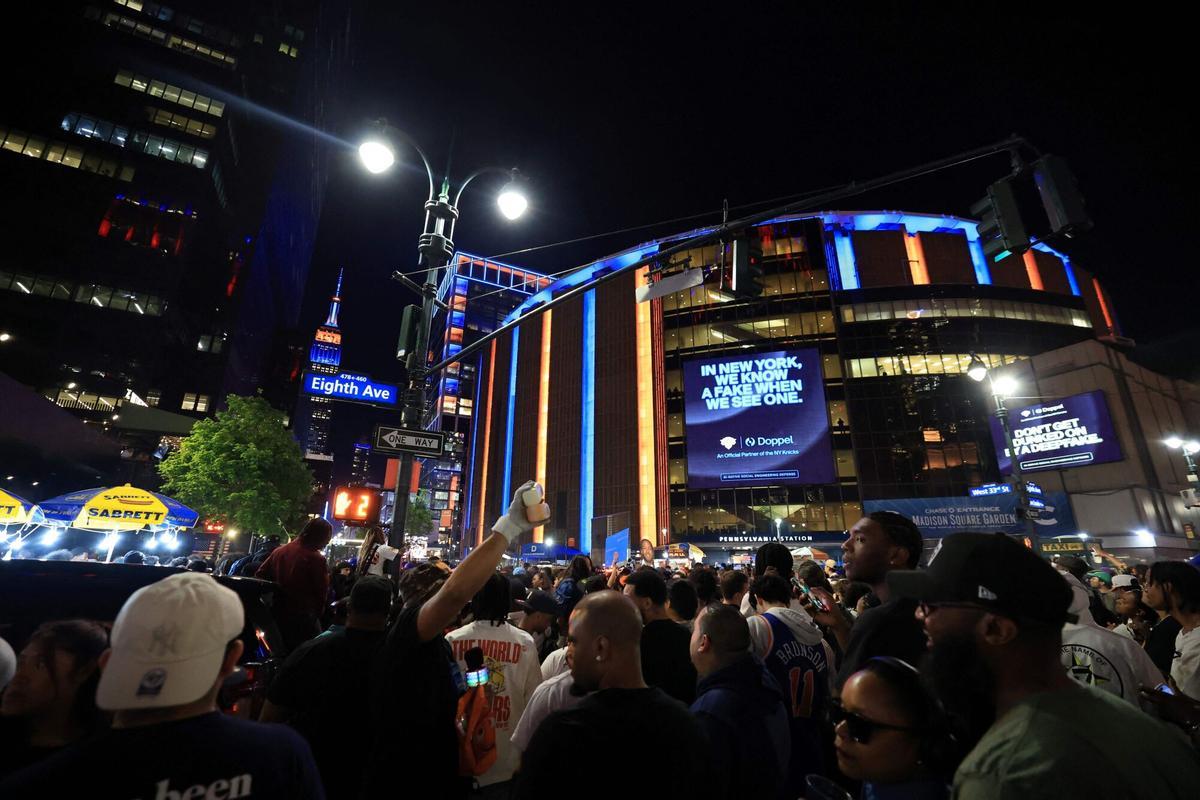 Aficionados mirando el tablero de precios en el Madison Square Garden mientras se anuncian los valores de las entradas para la final de la NBA.