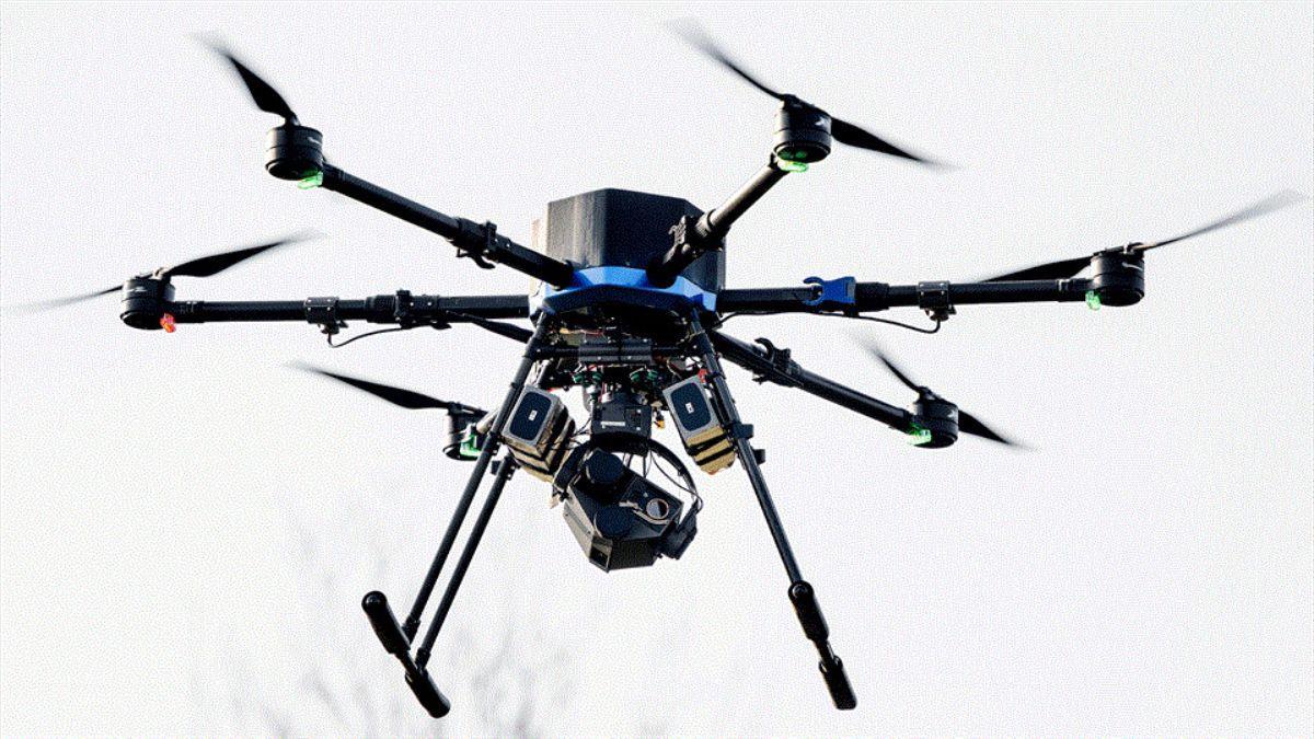 Dron autónomo sobre el mar entregando un chaleco salvavidas con señal GPS a una persona caída al agua
