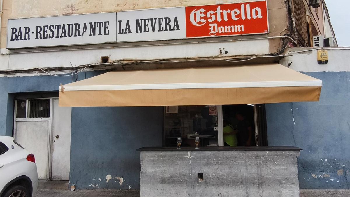 Vista del interior del Bar La Nevera con mesas ocupadas por trabajadores del puerto